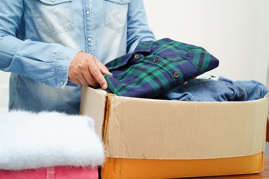 Clothes donations in cardboard box for volunteer. photo