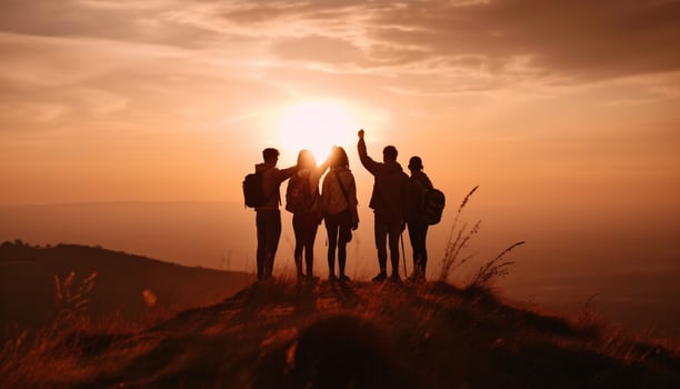 Group of people hiking mountain peak at sunset generated by AI photo