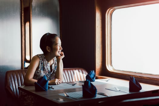 Happy smiling woman sitting alone in restaurant looking away. photo