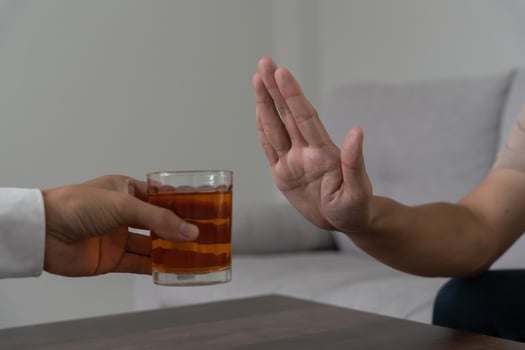 man refuses say no and avoid to drink an alcohol whiskey , stopping hand sign male, alcoholism treatment, alcohol addiction, quit booze, Stop Drinking Alcohol. Refuse Glass liquor, unhealthy, reject photo