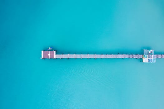 Top view of tourist canoeing by wooden pier in turquoise sea on summer at tropical island photo