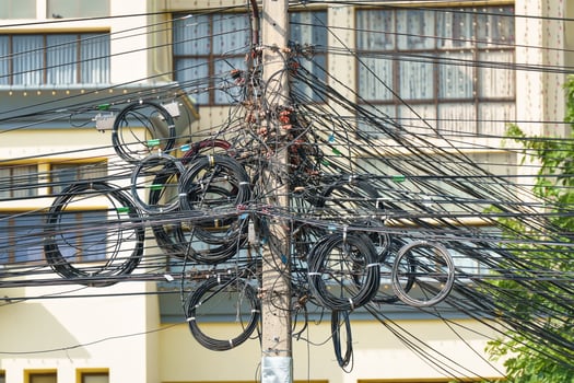 Power wire and communication, telephone, internet cable tangled up on the electric utility pole photo