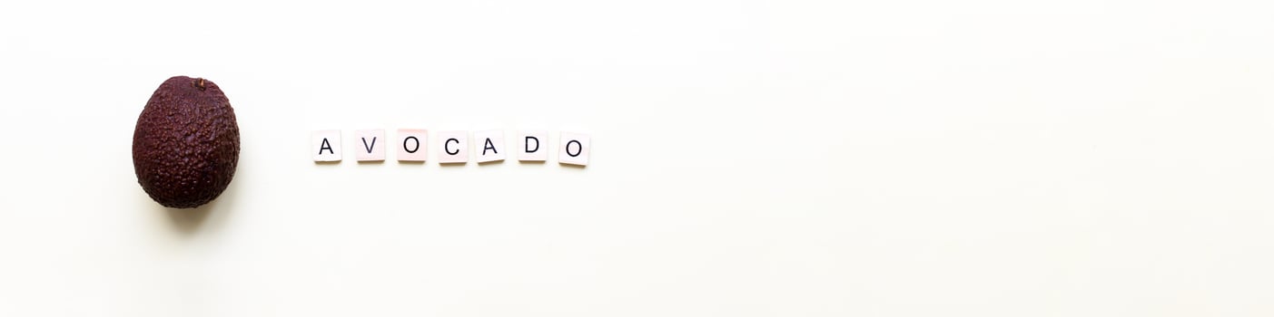 Banner Flatly avocado. Word avocado from wooden letters. Veganism, fruitarianism photo