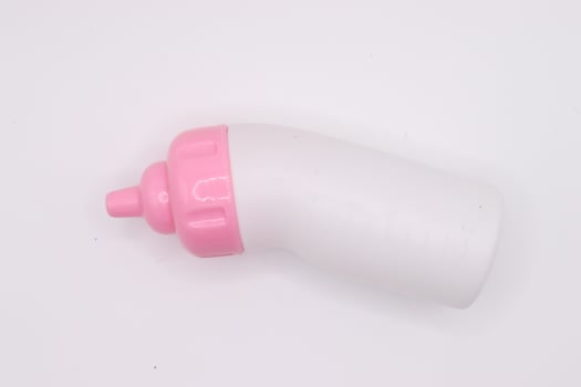 Miniature milk bottle dolls ,mini baby bottles dollhouse in pink and white color on white background,isolated baby bottle,baby toys,copy space up and down photo