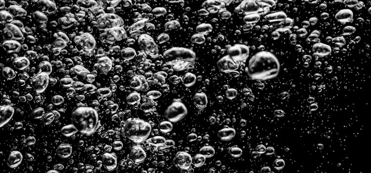 Soda water bubbles splashing underwater against black background. photo