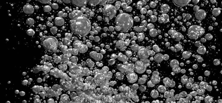 Soda water bubbles splashing underwater against black background. photo