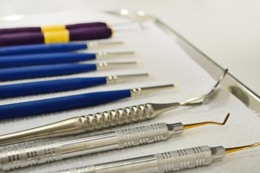 Pile of dentist tools lying at white tissue. Dental tools, dental Instruments. photo