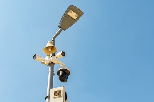 Cluster of security cameras on a lamppost, in an public Park on the sky background, with copy space. photo