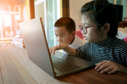 two asian children learning to use computer laptop at home living room photo