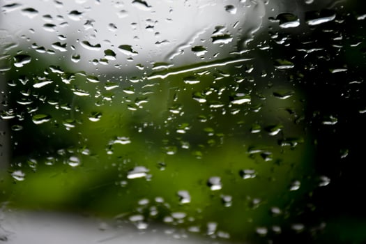 Blurred image of raindrops on the rear view mirror of car, soft focus photo