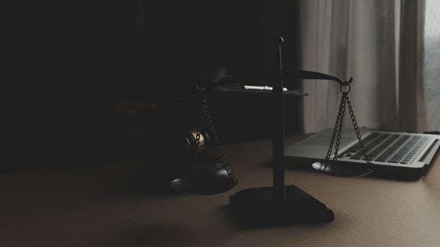 Business and lawyers discussing contract papers with brass scale on desk in office. Law, legal services, advice, justice and law concept picture with film grain effect photo