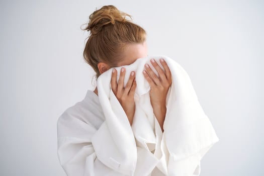 The girl wipes her face with a terry towel. photo