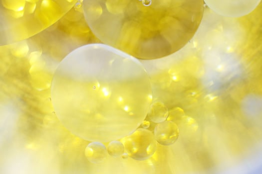 Gold Oil bubbles close up. circles of water macro. abstract shiny yellow background photo