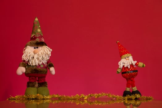 two santa claus and gnomes on a red background photo
