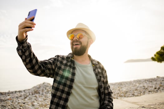 Traveler or tourist take self photo with smartphone on sea view - alone travel and technologies and millennial or gen z lifestyle concept.