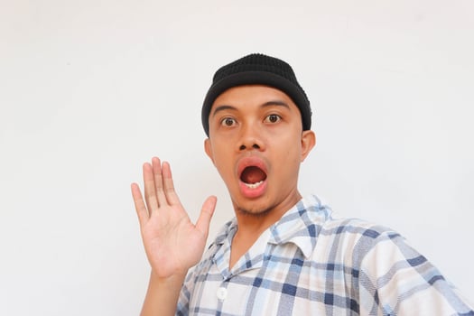Surprise adult man wearing pajamas and beanie cap looking at camera. Isolated on a white background photo