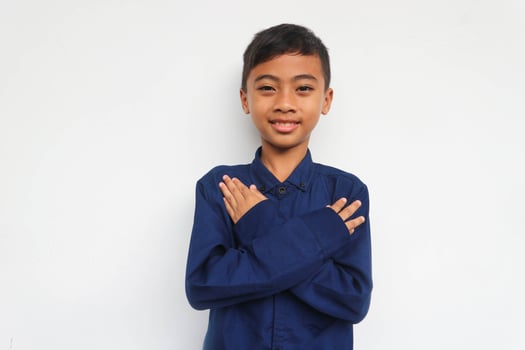 Smiling confidence boy looking at the camera while put his hand on chest, isolated on white background photo