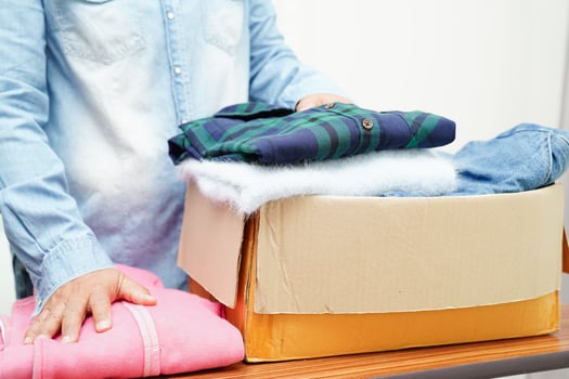 Clothes donations in cardboard box for volunteer. photo