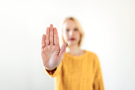 woman raised her hand for dissuade, campaign stop violence against women. Blond woman raised her hand for dissuade with copy space photo