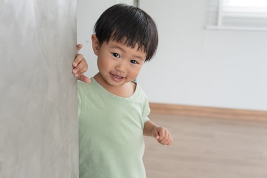 playing hide and seek standing next a wall house, Adorable child having fun in the home. happy family have fun with kids, activity, learning photo
