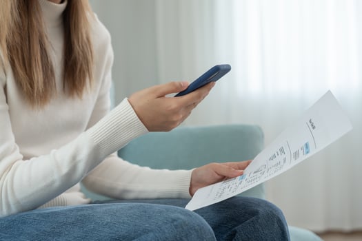 woman use phone scan barcode or QR codes to pay credit card bill after receiving document invoice. payment, receive, paying electricity, digital payments, technology, scanning, financial transactions photo
