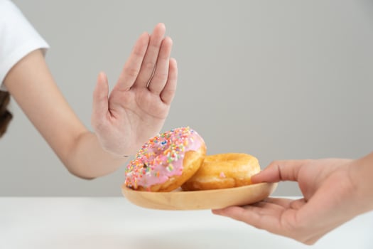 Diet and dieting. Beauty slim female body confuse donut. Woman in exercise clothes achieves weight loss goal for healthy life, crazy about thinness, thin waist, nutritionist. photo
