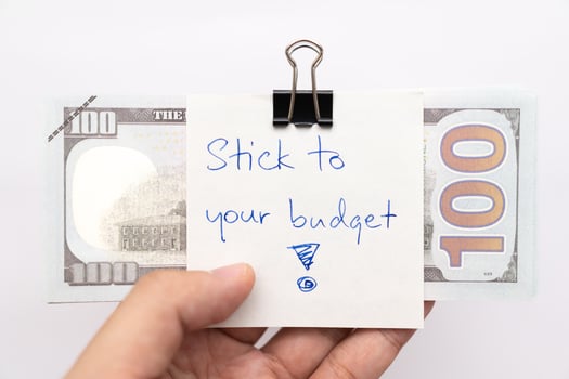 Dollars cash money with text written note STICK TO YOUR BUDGET. concept of financial planning to save money by spending less. Finance and business concept. photo