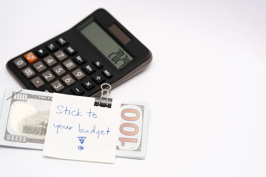 Dollars cash money with text written note STICK TO YOUR BUDGET. concept of financial planning to save money by spending less. Finance and business concept. photo