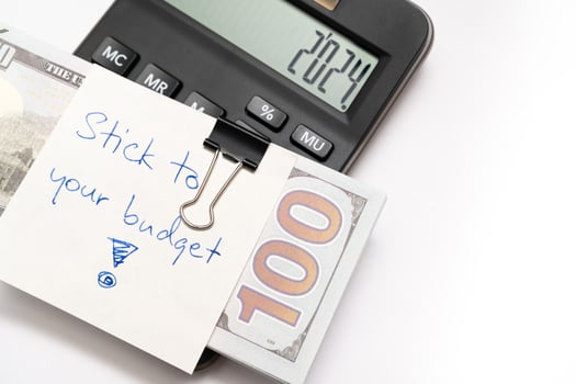 Dollars cash money with text written note STICK TO YOUR BUDGET. concept of financial planning to save money by spending less. Finance and business concept. photo