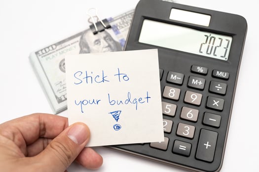 Dollars cash money with text written note STICK TO YOUR BUDGET. concept of financial planning to save money by spending less. Finance and business concept. photo