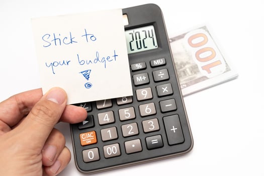 Dollars cash money with text written note STICK TO YOUR BUDGET. concept of financial planning to save money by spending less. Finance and business concept. photo
