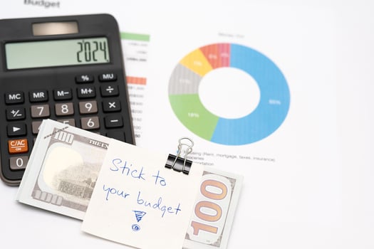 Dollars cash money with text written note STICK TO YOUR BUDGET. concept of financial planning to save money by spending less. Finance and business concept. photo