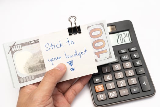 Dollars cash money with text written note STICK TO YOUR BUDGET. concept of financial planning to save money by spending less. Finance and business concept. photo