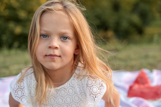 funny portrait of little baby girl wearing white dress outdoors photo