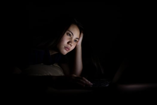 Young asian women work late at night stressed out. Tired and exhausted from working on computer laptop in the bedroom. photo
