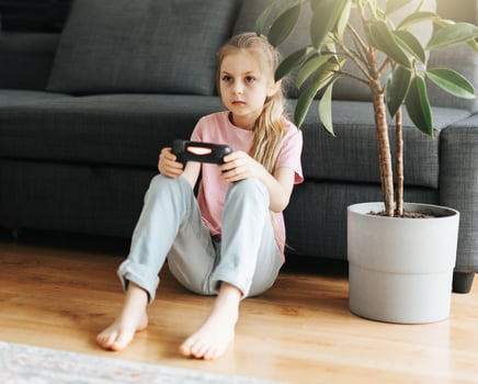 Girl playing video game at home photo