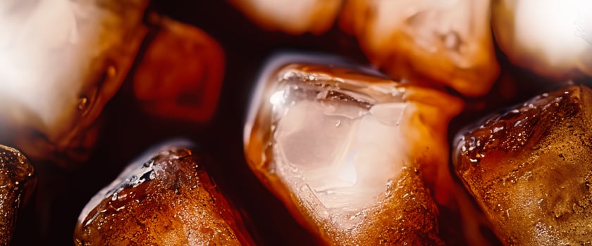 Cola with Ice. Close up of the ice cubes in cola water. Texture of carbonate drink with bubbles in glass. Cola soda and ice splashing fizzing or floating up to top of surface. Cold drink background. photo