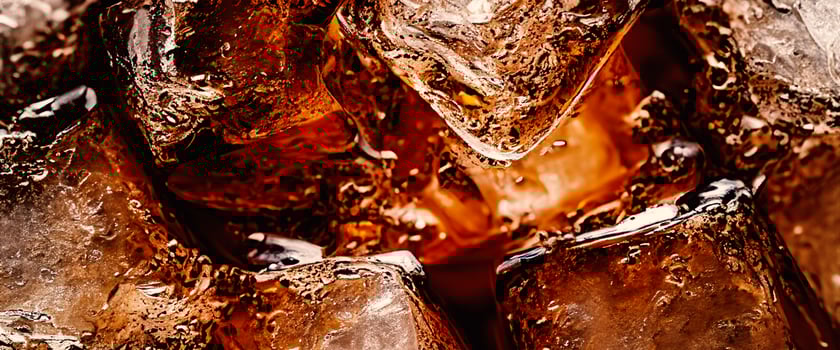 Cola with Ice. Close up of the ice cubes in cola water. Texture of carbonate drink with bubbles in glass. Cola soda and ice splashing fizzing or floating up to top of surface. Cold drink background. photo