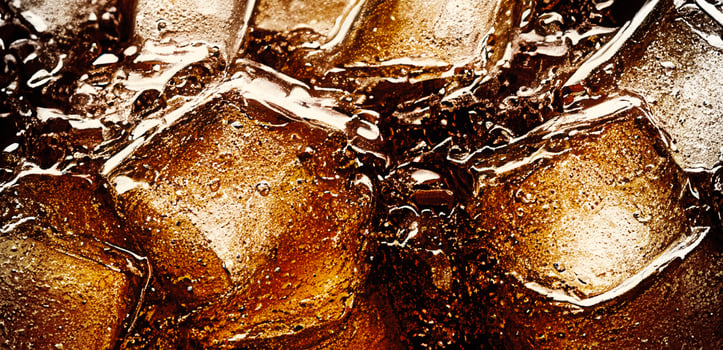 Cola with Ice. Close up of the ice cubes in cola water. Texture of carbonate drink with bubbles in glass. Cola soda and ice splashing fizzing or floating up to top of surface. Cold drink background. photo