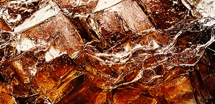 Cola with Ice. Close up of the ice cubes in cola water. Texture of carbonate drink with bubbles in glass. Cola soda and ice splashing fizzing or floating up to top of surface. Cold drink background. photo
