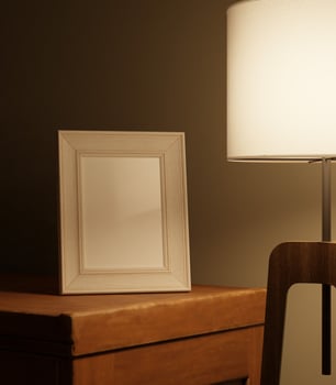 a portrait of little frame mockup in the dark lit by standing lamp on the wooden table photo
