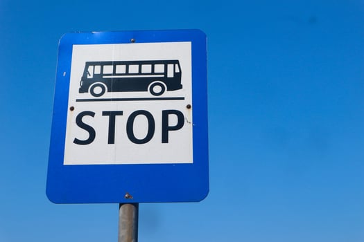Bus stop sign on the bright sky photo