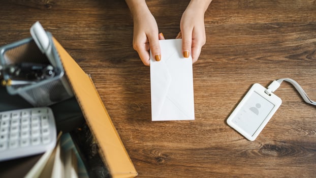 Business woman sending resignation letter and packing Stuff Resign Depress or carrying business cardboard box by desk in office. Change of job or fired from company photo