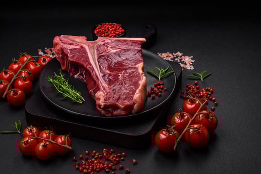 Raw juicy beef t-bone steak with salt, spices and herbs photo
