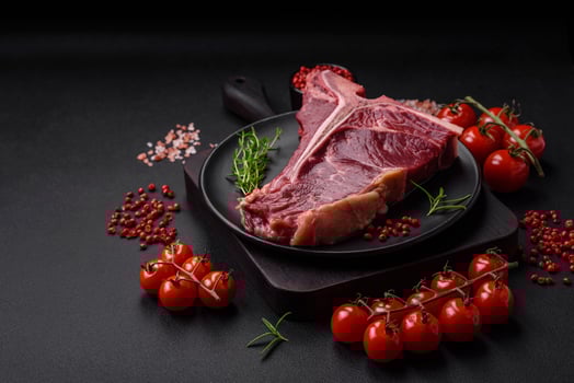 Raw juicy beef t-bone steak with salt, spices and herbs photo