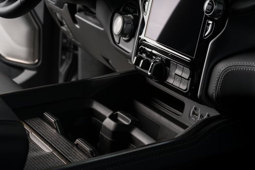 cup holder close up inside a black luxury car, touch screen system display photo