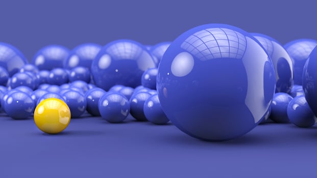 Bright yellow ball stands out from the crowd of blue spheres photo