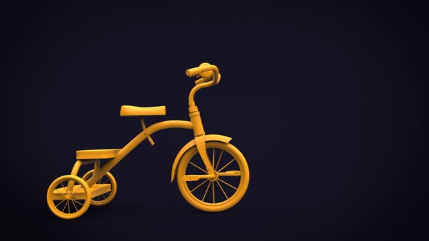 Vintage yellow toy tricycle on black background photo