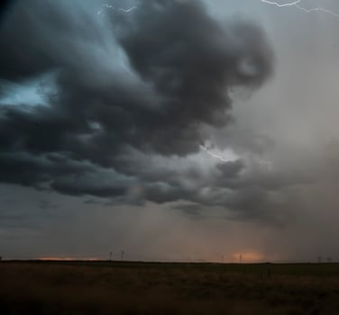 a stormy sky with lightning and clouds over a field photo