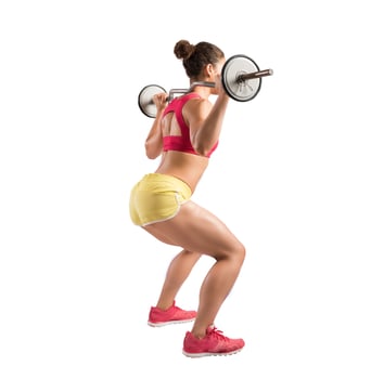 Athletic girl works out at the gym with a barbell photo